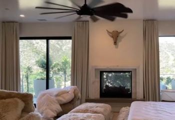 Custom motorized blackout curtains fully closed on a large master bedroom window in Tustin, providing total privacy and light blocking.