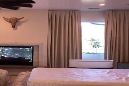 Stylish draperies and curtains with automated features, enhancing the comfort and décor of a spacious Tustin master bedroom.